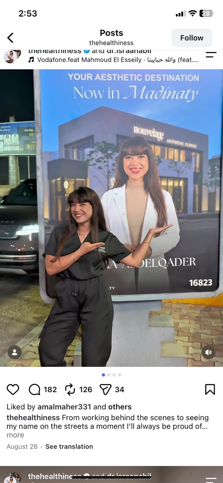Dr. Israa beside her billboard, from her own post
